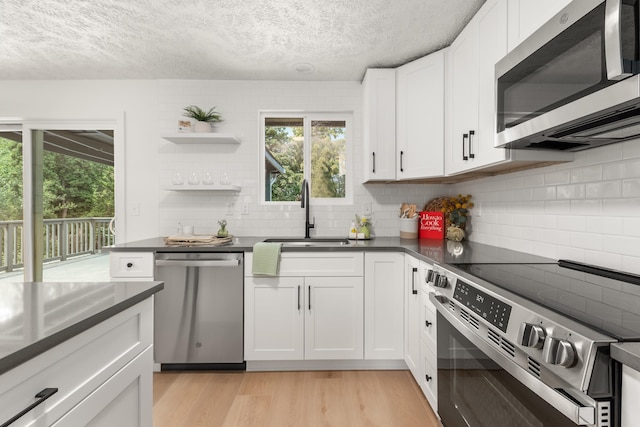 7721 N Wilding Dr, Spokane, WA 99208 - kitchen with stainless steel appliances, dark countertops, healthy amount of natural light, tasteful backsplash, and a textured ceiling