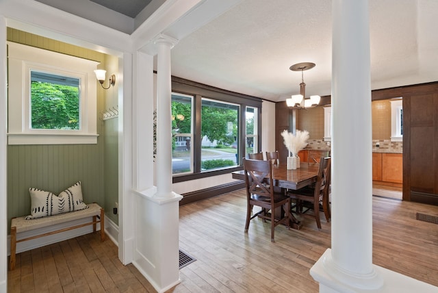 1315 N Hollis St, Spokane, WA 99201 - dining room with ornate columns, plenty of natural light, light wood-type flooring, and a chandelier