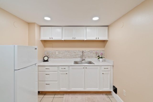 1315 N Hollis St, Spokane, WA 99201 - kitchen featuring freestanding refrigerator, light tile patterned floors, tasteful backsplash, light countertops, and white cabinetry