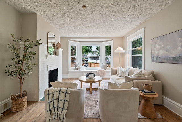 1315 N Hollis St, Spokane, WA 99201 - living room featuring hardwood / wood-style flooring, a textured ceiling, and a fireplace