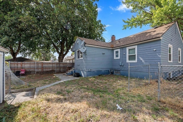 1630 E Broad Ave, Spokane, WA 99207 - rear view of property with a fenced backyard, a chimney, and roof with shingles