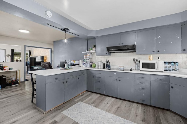 1630 E Broad Ave, Spokane, WA 99207 - kitchen with gray cabinets, under cabinet range hood, white microwave, and a peninsula