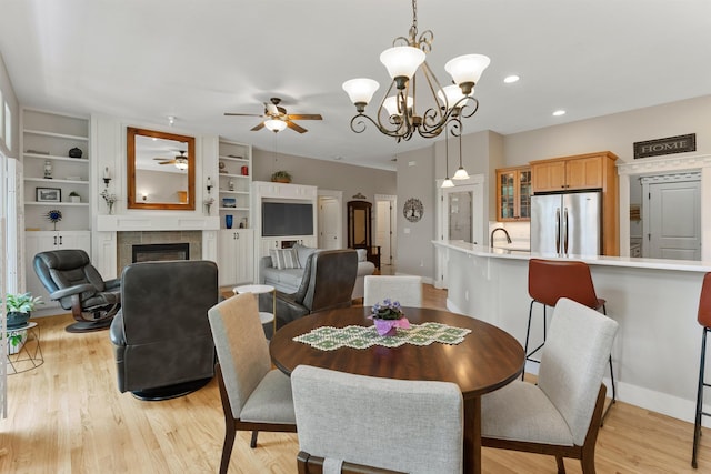 718 W Qualchan Ln, Spokane, WA 99224 - dining space with a ceiling fan, a tiled fireplace, light wood-type flooring, built in shelves, and recessed lighting