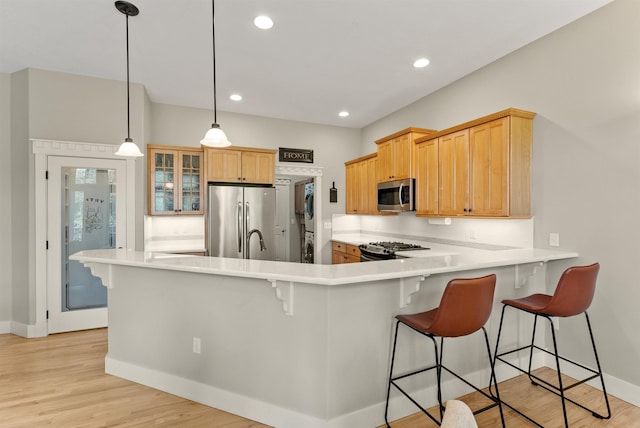 718 W Qualchan Ln, Spokane, WA 99224 - kitchen featuring appliances with stainless steel finishes, a peninsula, a breakfast bar area, light wood-style flooring, and recessed lighting