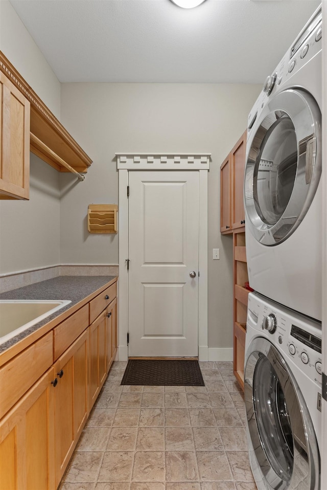 718 W Qualchan Ln, Spokane, WA 99224 - washroom featuring stacked washer and clothes dryer, cabinet space, and light stone finish floors