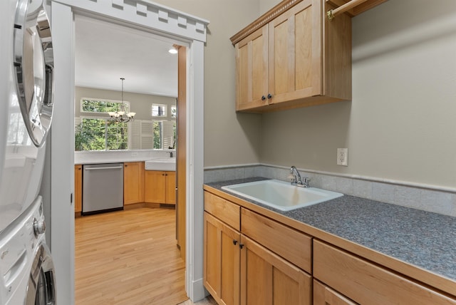 718 W Qualchan Ln, Spokane, WA 99224 - kitchen with dishwasher, stacked washer / dryer, light wood-style floors, a chandelier, and dark countertops