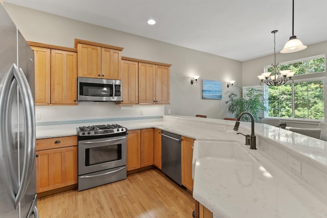 718 W Qualchan Ln, Spokane, WA 99224 - kitchen featuring stainless steel appliances, light wood-type flooring, decorative light fixtures, light stone countertops, and a chandelier