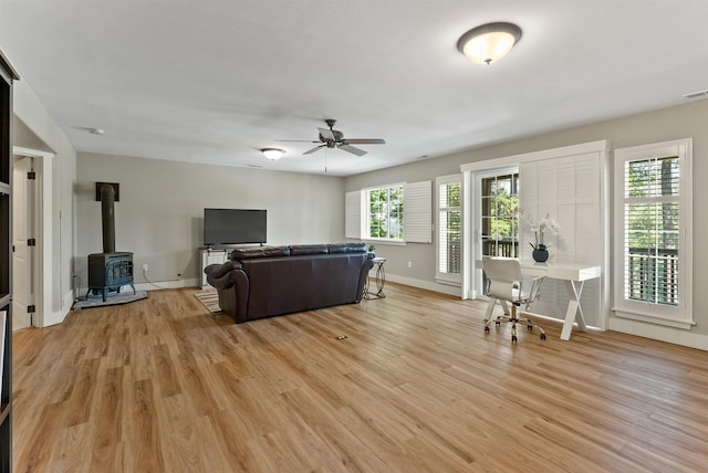 718 W Qualchan Ln, Spokane, WA 99224 - living room featuring a wood stove, ceiling fan, and light wood-style flooring