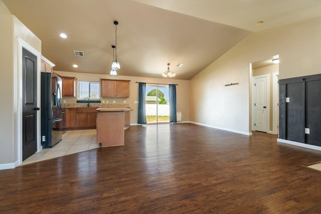 1819 N Center Ln, Spokane Valley, WA 99212 - kitchen featuring black fridge with ice dispenser, open floor plan, lofted ceiling, light countertops, and light wood-style floors