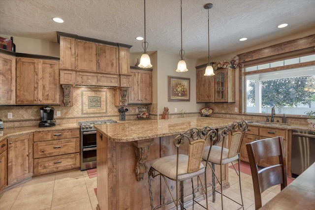 5908 N Bridget Rd, Spokane, WA 99208 - kitchen with appliances with stainless steel finishes, brown cabinetry, a kitchen bar, decorative backsplash, and light tile patterned floors