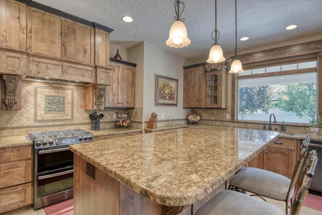 5908 N Bridget Rd, Spokane, WA 99208 - kitchen featuring range with two ovens, light stone countertops, backsplash, a kitchen bar, and brown cabinetry