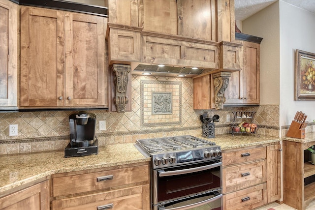 5908 N Bridget Rd, Spokane, WA 99208 - kitchen featuring stainless steel gas stove, tasteful backsplash, light stone countertops, and premium range hood
