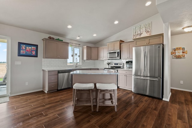 818 S Apple Pl, Spokane, WA 99224 - kitchen featuring stainless steel appliances, decorative backsplash, a center island, dark wood-style floors, and lofted ceiling