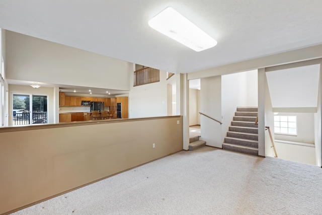 19915 S Ritchey Rd, Cheney, WA 99004 - below grade area with light carpet, stairway, and black fridge