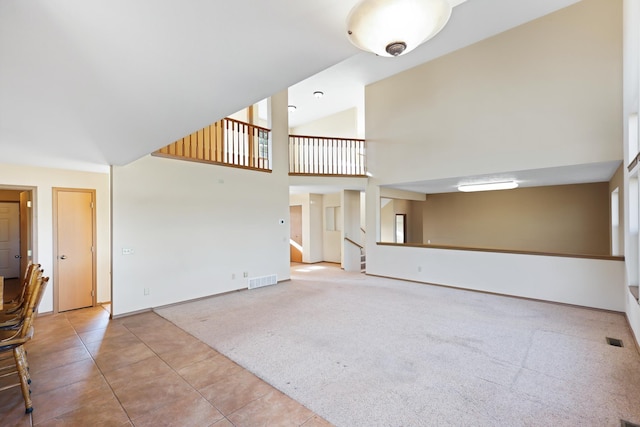 19915 S Ritchey Rd, Cheney, WA 99004 - unfurnished living room with stairs, tile patterned flooring, high vaulted ceiling, and carpet flooring