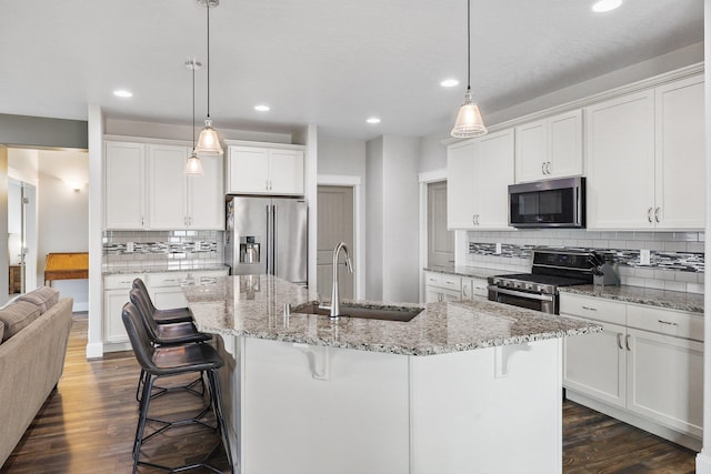 1418 S Cavalier St, Greenacres, WA 99016 - kitchen with stainless steel appliances, decorative backsplash, recessed lighting, a kitchen bar, and dark wood-style flooring