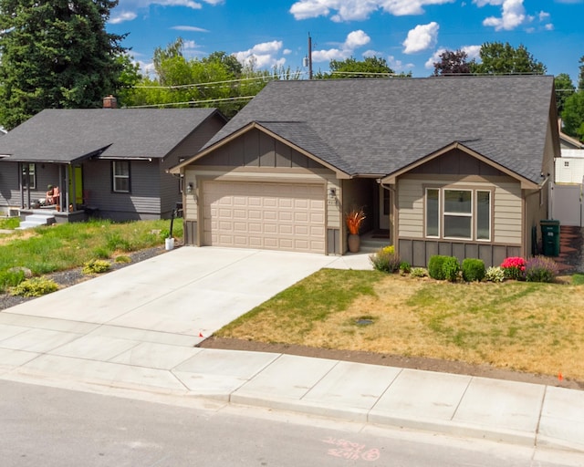 4017 E Hartson Ave, Spokane, WA 99202 - ranch-style house featuring board and batten siding, an attached garage, a shingled roof, concrete driveway, and a front lawn