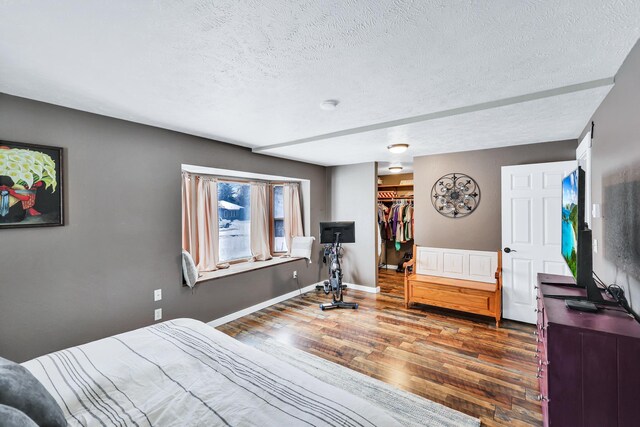 2202 E 50th Ave, Spokane, WA 99223 - bedroom with wood finished floors, a textured ceiling, a walk in closet, and a closet