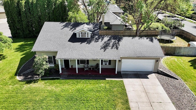2202 E 50th Ave, Spokane, WA 99223 - view of front of house with a trampoline, roof with shingles, driveway, a garage, and a porch