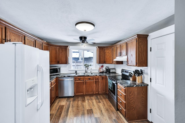 2202 E 50th Ave, Spokane, WA 99223 - kitchen featuring appliances with stainless steel finishes, a ceiling fan, wood finished floors, decorative backsplash, and a textured ceiling