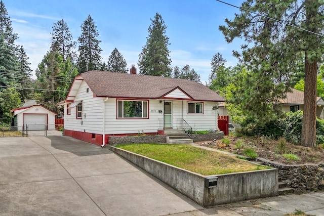 3918 E 8th Ave, Spokane, WA 99202 - view of front facade with concrete driveway, an outbuilding, a garage, a chimney, and roof with shingles