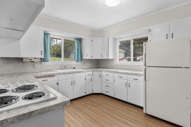 3918 E 8th Ave, Spokane, WA 99202 - kitchen featuring freestanding refrigerator, light wood-style floors, light countertops, white cabinetry, and decorative backsplash