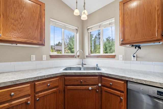 3224 E 42nd Ave, Spokane, WA 99223 - kitchen featuring stainless steel dishwasher, brown cabinetry, light countertops, and pendant lighting