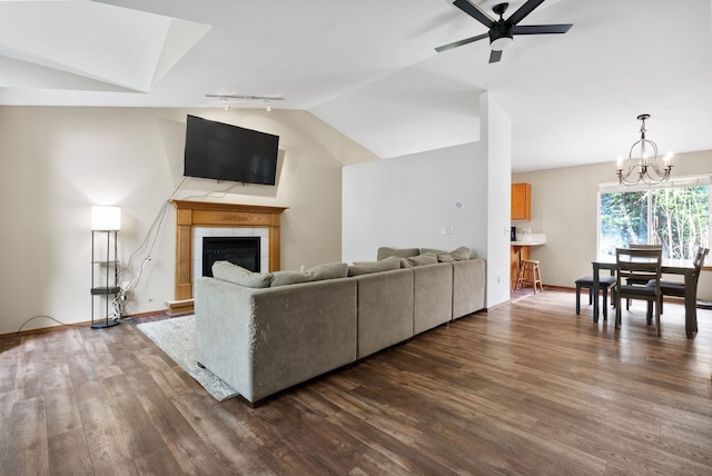 3224 E 42nd Ave, Spokane, WA 99223 - living area featuring lofted ceiling, a ceiling fan, dark wood-style floors, a chandelier, and a tiled fireplace