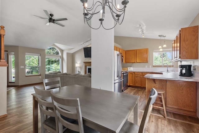 3224 E 42nd Ave, Spokane, WA 99223 - dining room featuring lofted ceiling, wood finished floors, ceiling fan, a fireplace, and a chandelier
