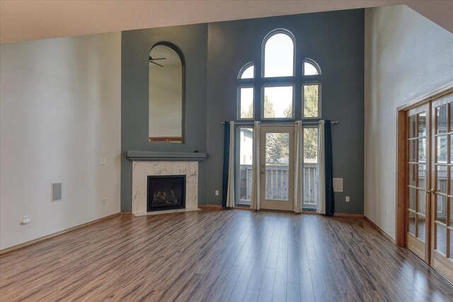 3023 S Winthrop Ln Unit 3023, Spokane, WA 99203 - unfurnished living room featuring wood finished floors, healthy amount of natural light, a towering ceiling, and a high end fireplace