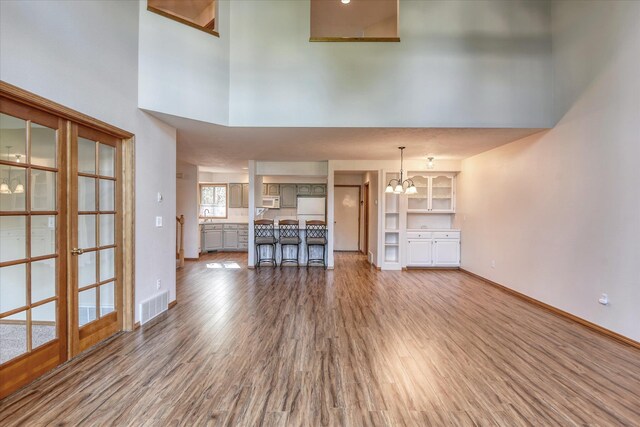 3023 S Winthrop Ln Unit 3023, Spokane, WA 99203 - unfurnished living room featuring wood finished floors, a chandelier, and a high ceiling