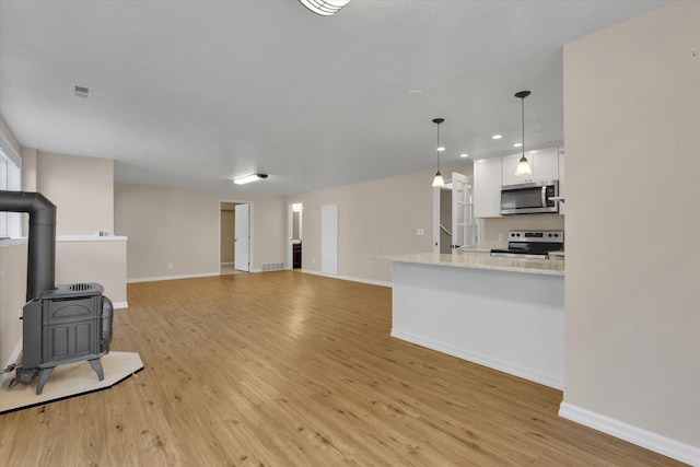 2019 S Saint Charles Rd, Veradale, WA 99037 - unfurnished living room with a wood stove, light wood-type flooring, and recessed lighting
