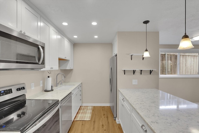 2019 S Saint Charles Rd, Veradale, WA 99037 - kitchen with stainless steel appliances, light wood-type flooring, white cabinets, recessed lighting, and light stone counters