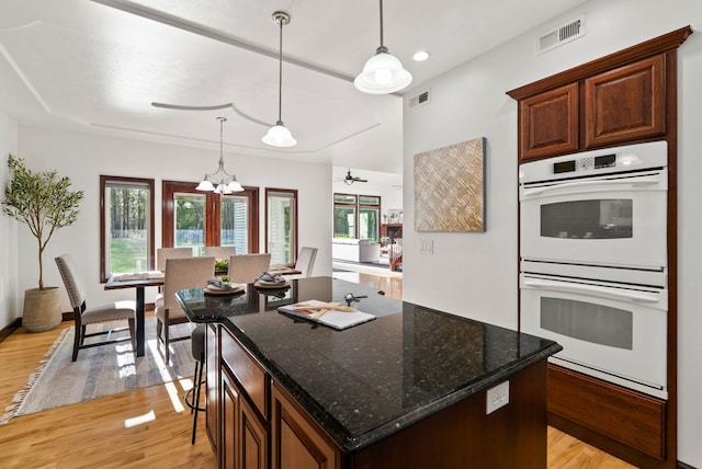 4045 Maple St, Loon Lake, WA 99148 - kitchen featuring white double oven, light wood-type flooring, pendant lighting, a chandelier, and a kitchen island