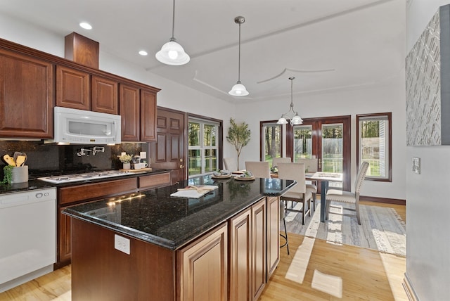 4045 Maple St, Loon Lake, WA 99148 - kitchen with white appliances, light wood-type flooring, tasteful backsplash, pendant lighting, and dark stone countertops