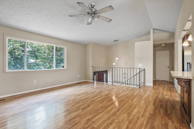 1707 S Early Dawn Dr, Spokane Valley, WA 99037 - unfurnished room featuring light wood-style floors, a ceiling fan, a textured ceiling, and vaulted ceiling