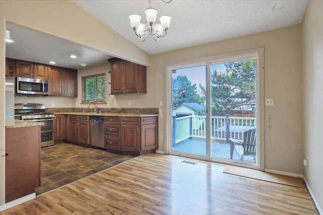 1707 S Early Dawn Dr, Spokane Valley, WA 99037 - kitchen featuring stainless steel appliances, dark wood-type flooring, vaulted ceiling, a chandelier, and hanging light fixtures