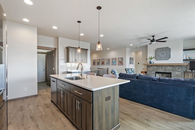 8814 E Clearview Ln, Spokane, WA 99217 - kitchen with ceiling fan, light countertops, a center island with sink, light wood-style floors, and recessed lighting