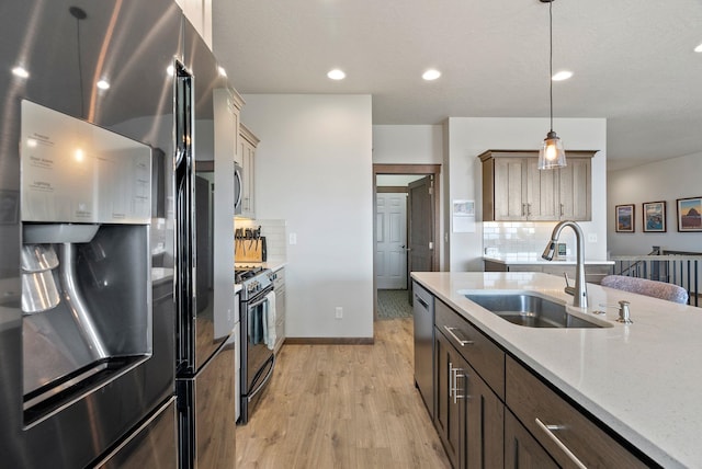 8814 E Clearview Ln, Spokane, WA 99217 - kitchen with stainless steel appliances, light wood finished floors, backsplash, hanging light fixtures, and recessed lighting