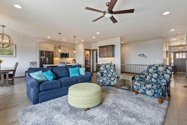 8814 E Clearview Ln, Spokane, WA 99217 - living area with a chandelier, light wood-style flooring, ceiling fan, and recessed lighting