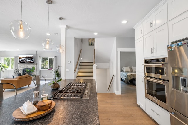4171 S Westway Dr, Coeur D Alene, ID 83814 - kitchen with appliances with stainless steel finishes, light wood finished floors, open floor plan, white cabinetry, and recessed lighting