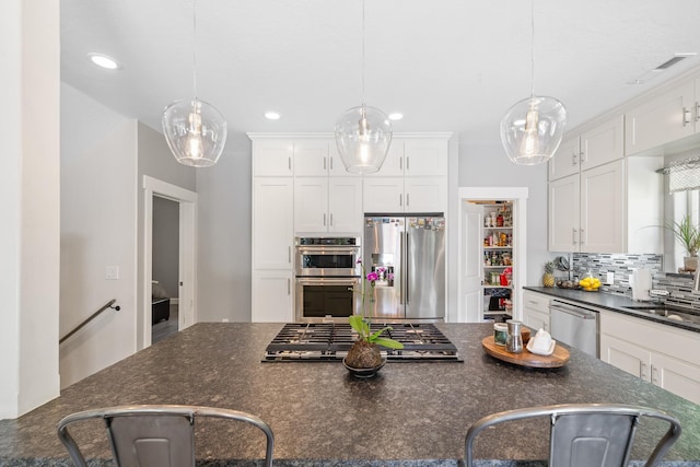 4171 S Westway Dr, Coeur D Alene, ID 83814 - kitchen featuring appliances with stainless steel finishes, white cabinets, decorative backsplash, decorative light fixtures, and recessed lighting