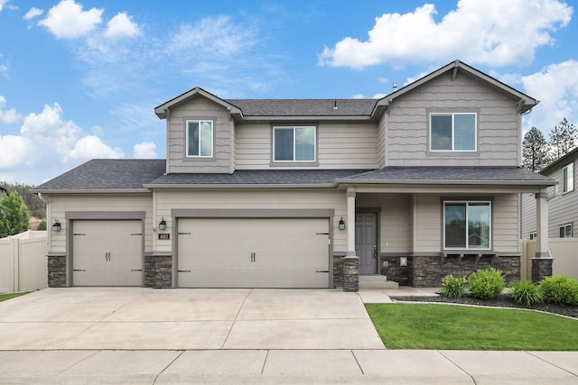 4813 S Lapwai Ln, Spokane, WA 99206 - view of front facade featuring stone siding, concrete driveway, a garage, and roof with shingles