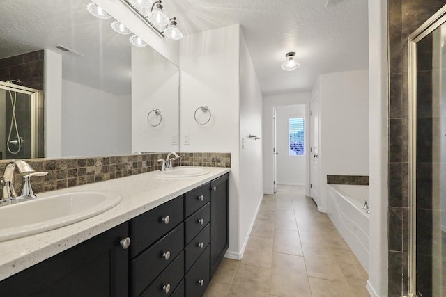 4813 S Lapwai Ln, Spokane, WA 99206 - bathroom featuring a shower stall, a garden tub, tile patterned floors, double vanity, and a textured ceiling