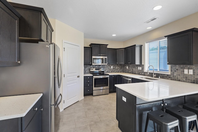 4813 S Lapwai Ln, Spokane, WA 99206 - kitchen with stainless steel appliances, a peninsula, tasteful backsplash, light tile patterned floors, and recessed lighting