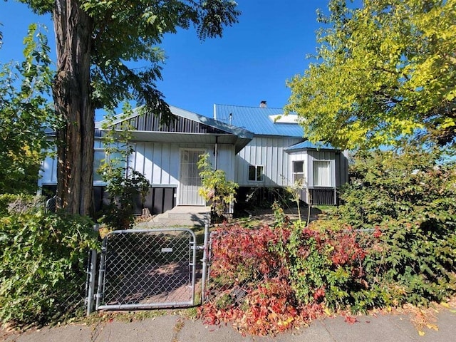 1528 E Boone Ave, Spokane, WA 99202 - view of front of home featuring a gate, board and batten siding, a fenced front yard, and a metal roof