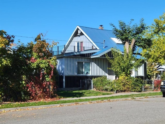 1528 E Boone Ave, Spokane, WA 99202 - view of front of property with a chimney, a metal roof, a balcony, board and batten siding, and a standing seam roof