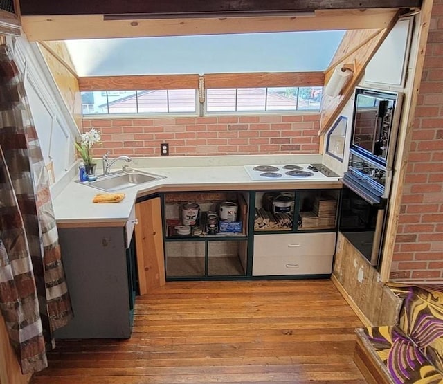 1528 E Boone Ave, Spokane, WA 99202 - kitchen featuring oven, light wood finished floors, light countertops, plenty of natural light, and brick wall