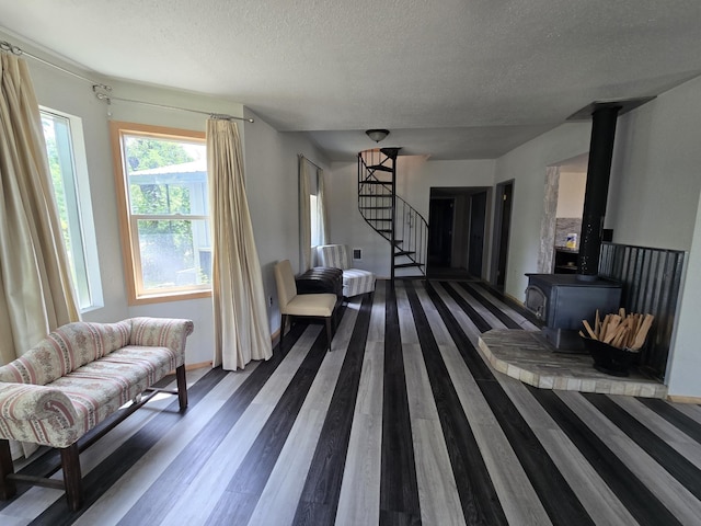 1528 E Boone Ave, Spokane, WA 99202 - living room with dark wood-style flooring, a textured ceiling, stairway, and a wood stove
