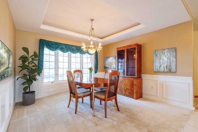 10207 N Comanche Dr, Spokane, WA 99208 - dining space with a chandelier, a decorative wall, a raised ceiling, wainscoting, and carpet